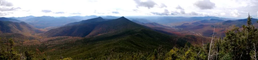 Expansive autumn view of the White Mountains and Franconia Notch from higher elevations