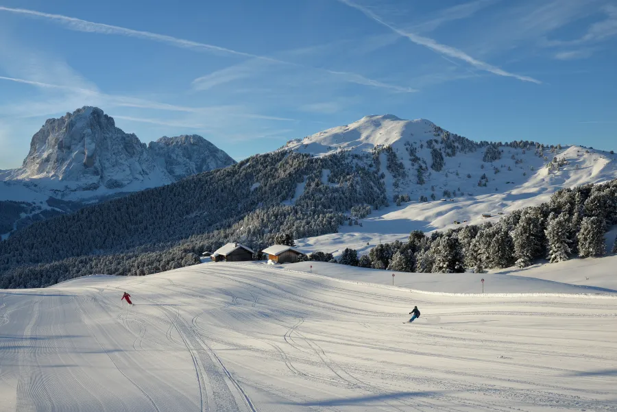 Crisp sunny alpine slope with distinct terrain shadows and razor-sharp mountain ridgelines