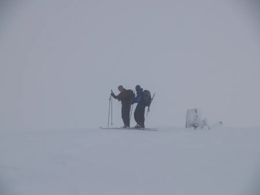 Total alpine whiteout where cloud cover blends ground and sky into featureless white void