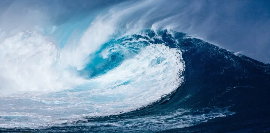 A massive curling ocean wave pitching forward before breaking